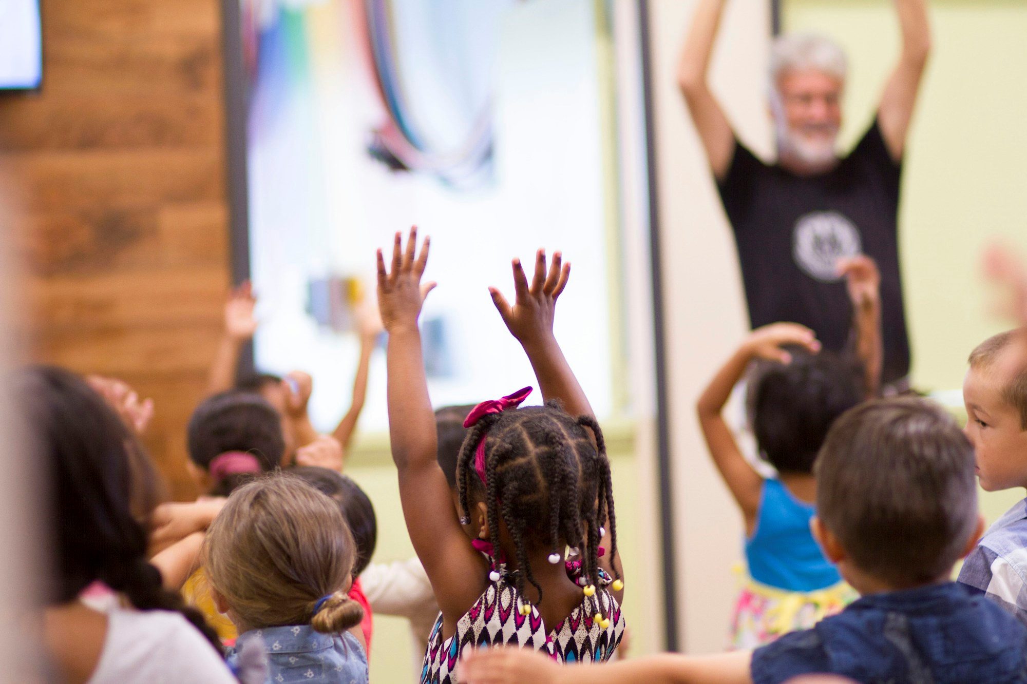 Children with their hands raised at a performance